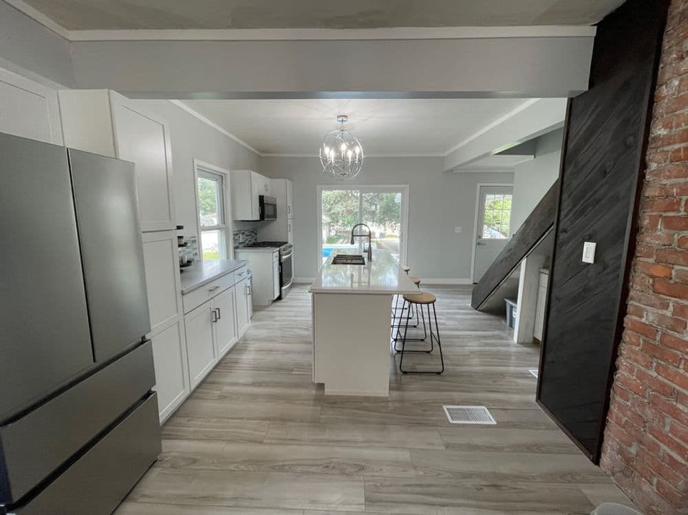 Modern kitchen with stainless steel appliances, island seating, and open layout with natural light.