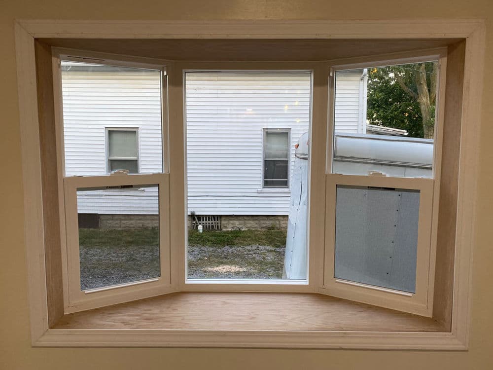 Newly installed bay window showing three panes with a view of the exterior.