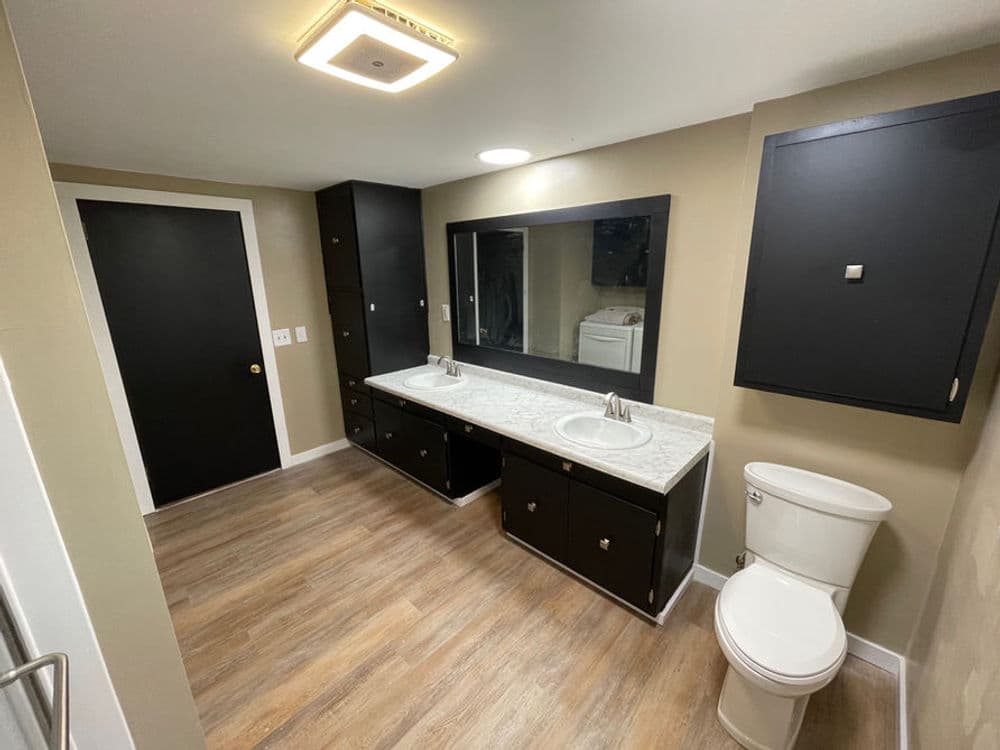 Modern bathroom design with double vanity, large mirror, and sleek cabinetry.